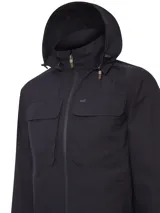 Campera cortaviento impermeable de color azul marino, con capucha desmontable, cierre frontal termosellado y bolsillos frontales con solapa. Presenta tecnología de secado rápido, aislamiento térmico y protección contra el viento, con costuras selladas para mayor resistencia.