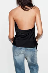 Top de satén con cuello halter, diseño drapeado en el frente y bajo asimétrico. Presenta espalda descubierta y cierre con lazada en el cuello.