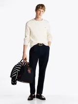 Sweater de punto trenzado color blanco con cuello redondo, mangas largas y detalles acanalados en puños y bajo, de la marca Tommy Hilfiger.