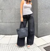 Pantalón de jean color negro, de corte recto y tiro medio, con costuras verticales decorativas en el frente y bolsillos traseros clásicos.