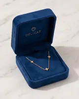 Collar de cadena fina con baño de oro, adornado con pequeños dijes en forma de estrella de cuatro puntas con incrustaciones de circonias.