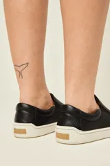 Championes slip-on negros de cuero graneado, con elásticos laterales para un calce rápido. Tienen plantilla forrada en cuero y suela fina, flexible y plana (zero drop).