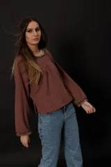 Buzo color chocolate de punto en lanilla con diseño de ochos, corte holgado y escote redondo con flecos.