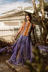 Musculosa tejida en crochet con hilado de algodón y seda, con diseño a rayas horizontales en tonos naranja, marrón, blanco y azul.