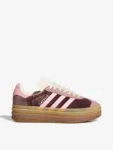 Zapatillas Adidas Gazelle Bold con plataforma, capellada de terciopelo color marrón y rosa, con las tres tiras laterales en rosa claro y suela de goma color caramelo.
