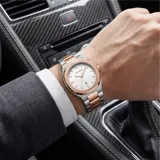 Reloj analógico Mini Focus con movimiento de cuarzo japonés, caja de aleación metálica y malla de acero inoxidable bicolor en tonos plata y oro rosa. Presenta una esfera blanca minimalista con indicadores de hora lineales y ventana de fecha.