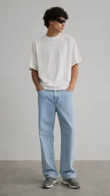 Pantalón de jean corte regular, color azul claro, con diseño de cinco bolsillos y cierre frontal con botón y cremallera.