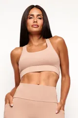 Top deportivo de alto rendimiento con diseño de espalda nadador, confeccionado en tejido técnico con protección UV50+. Cuenta con bolsillos integrados y detalles reflectivos para mayor funcionalidad durante el entrenamiento.