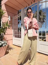 Bandolera compacta color rojo con textura de cuero, correa regulable y desmontable con diseño de rayas rojas y blancas. Cuenta con bolsillos frontales y cierre, interior forrado en tela.