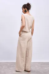 Pantalón de lino color beige, de corte palazzo con pinzas en la cintura.