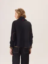 Saco de lana hervida color negro, con cuello solapa, cierre frontal de botones rústicos y bolsillos laterales. Presenta un diseño clásico con coderas y textura artesanal.