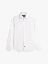 Camisa de corte regular de Tommy Hilfiger, confeccionada en sarga de algodón blanco, con cuello clásico, cierre frontal de botones y el característico logo bordado en el pecho.