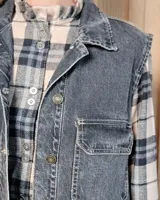 Chaleco de gabardina color tostado, con cuello camisero, cierre frontal con botones metálicos y dos bolsillos frontales con solapa.