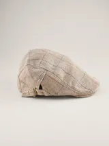 Boina estilo flat cap con diseño de espiga y cuadrillé en tonos beige, azul y rojo. Cuenta con una pequeña hebilla metálica ajustable en el lateral.