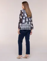 Cardigan abierto con blusa interior blanca, confeccionado en tejido de tul semitransparente con estampado animal print en tonos marrón y blanco, mangas 3/4 y escote redondo con detalles metálicos.