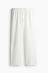 Pantalón blanco de lino con corte recto, cintura elástica y cordón ajustable.