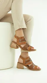 Sandalias de cuero color marrón con tiras anchas y hebilla lateral.