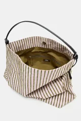 Bolso tipo shopper de tejido con diseño de cuadros en tonos verdes, blancos y marrones, decorado con apliques brillantes. Cuenta con asa de hombro ajustable en material sintético negro, cierre mediante botón imantado y bolsillo interior con cremallera.