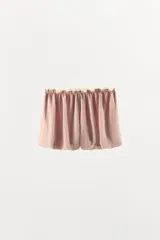 Shorts de tiro bajo en mezcla de viscosa y lino, color rosado con sutiles rayas verticales. Presenta cintura elástica fruncida con lazada frontal ajustable y aplicación de puntilla en contraste en el borde superior. Diseño de bajo abullonado tipo globo.