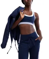 Top deportivo azul marino con contorno blanco y detalles en lila, de calce ajustado y breteles anchos.