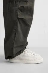 Zapatilla blanca de cordones fabricada en tejido transpirable de punto, con horma redonda y suela a tono.