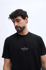 Remera de manga corta negra con textura marcada y estampa al frente con el texto "The Brooksfield Taste & Style".