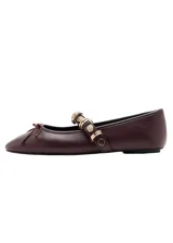 Zapato chatita de cuero sintético color marrón, con punta cuadrada, cordones decorativos en la capellada y una tira en el empeine adornada con tachas y argollas doradas.