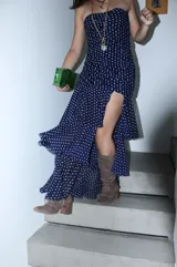 Vestido largo de fiesta color azul marino con estampado de lunares blancos, diseño strapless con frunces laterales y tajo frontal pronunciado.