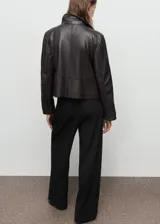 Pantalón de vestir negro de tiro medio con diseño wide leg, detalle de pinzas frontales, bolsillos laterales y cierre delantero con botón, gancho y cremallera ocultos.