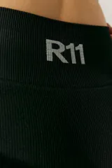 Short deportivo negro de tejido de morley con cintura ancha y logo a contratono en la cintura trasera.