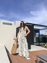 Conjunto de dos piezas compuesto por un top halter con escote en V y un pantalón de corte recto y tiro alto. Ambas prendas presentan un estampado vertical de puntos negros sobre fondo blanco.
