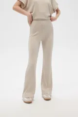 Pantalón acampanado de poliéster y lurex, color beige, de tiro alto y corte holgado.