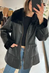 Campera reversible de cuero genuino napalán color negro, con cuello y detalles de corderito sintético, cierre frontal y bolsillos ribeteados.
