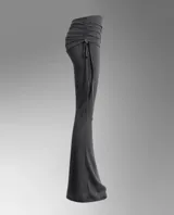 Pantalón largo negro de corte acampanado, tiro bajo, con cintura ancha drapeada y detalles de tiras colgantes en un lateral.