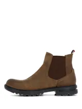 Botín estilo Chelsea color marrón oscuro, confeccionado en cuero con paneles laterales elásticos. Presenta una suela robusta de goma y EVA con tecnología de absorción de impactos y una presilla trasera con detalle de bandera.