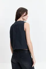 Chaleco de jean celeste con corte moderno, escote en V y tres botones.