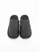 Pantuflas abiertas de hombre color gris, con textura exterior tramada, interior afelpado y suela de goma.
