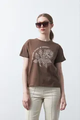 Remera negra de manga corta con estampado botánico en azul y la frase "NOTHING GROWS IN COMFORT".