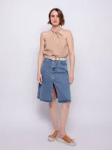 Top color beige sin mangas con nudo en el escote.