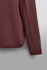 Sudadera técnica color bordó con capucha, cierre frontal completo y bolsillo en el pecho con cremallera oculta. Tejido elástico con interior efecto polar y estructura waffle. Presenta puños adaptables con ajuste para el pulgar.
