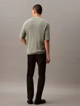 Pantalón chino de corte slim confeccionado en tejido elástico de algodón orgánico. Presenta cierre de botón y cremallera, bolsillos laterales y bolsillos traseros ribeteados.