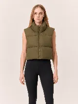 Chaleco puffer corto con cuello alto y cierre frontal, de diseño acolchado y corte relajado.