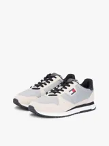 Zapatillas runner Tommy Jeans Eva de estilo urbano, confeccionadas con una combinación de textil, cuero y material sintético en tonos gris, beige y negro. Cuentan con cordones negros, suela bicolor y detalles de la marca.