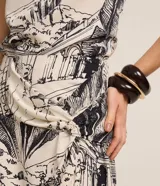 Pollera midi de Marfinno, confeccionada en viscolino con mezcla de lino y viscosa, con diseño estampado de paisajes modernistas en blanco y negro, nudo lateral y tajo frontal.