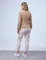 Buzo color beige de tejido combinado con mangas largas caladas y cuello redondo.