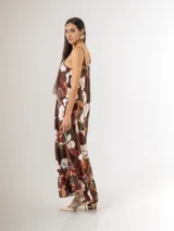 Vestido largo de satén azul marino con tirantes finos y escote en V, con gran estampado floral en tonos blancos, celestes y marrones, y diseño de caída fluida.