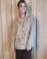 Sobrecamisa de paño color beige, con cuello solapa, cierre frontal de botones y dos bolsillos delanteros con solapa.