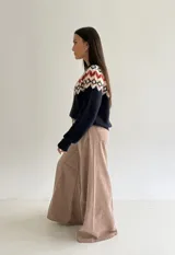 Sweater de cuello redondo con diseño de jacquard estilo nórdico en la parte superior, combinando tonos azul marino, blanco y rojo. Presenta mangas largas y puños acanalados.