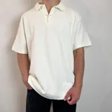 Chomba color crema con cuello polo, corte oversize y tejido acanalado.