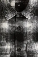 Sobrecamisa de franela con cuello inglés, cierre frontal de botones y dos bolsillos superiores con solapa. Presenta mangas largas con puños abotonados y bajo recto.